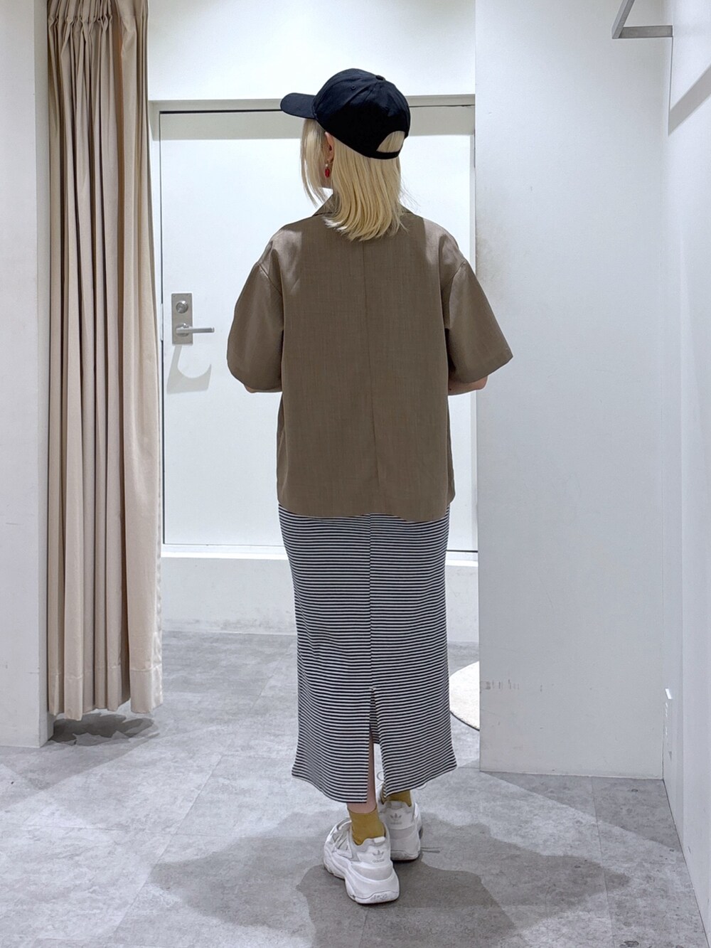 ブルー系のワンピース、ブラウン系のテーラードジャケット、ブラック系のショルダーバッグを着用したレディースの春コーディネートの4枚目の写真