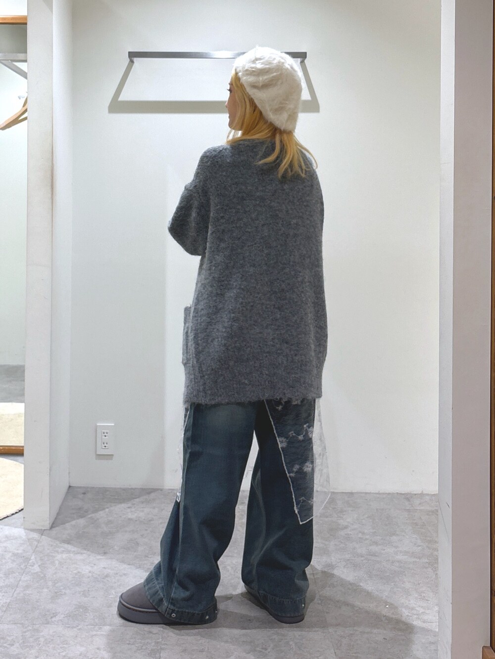 ブルー系のデニムパンツ、グレー系のブーツ、グレー系のハンドバッグを着用したレディースの秋コーディネートの4枚目の写真