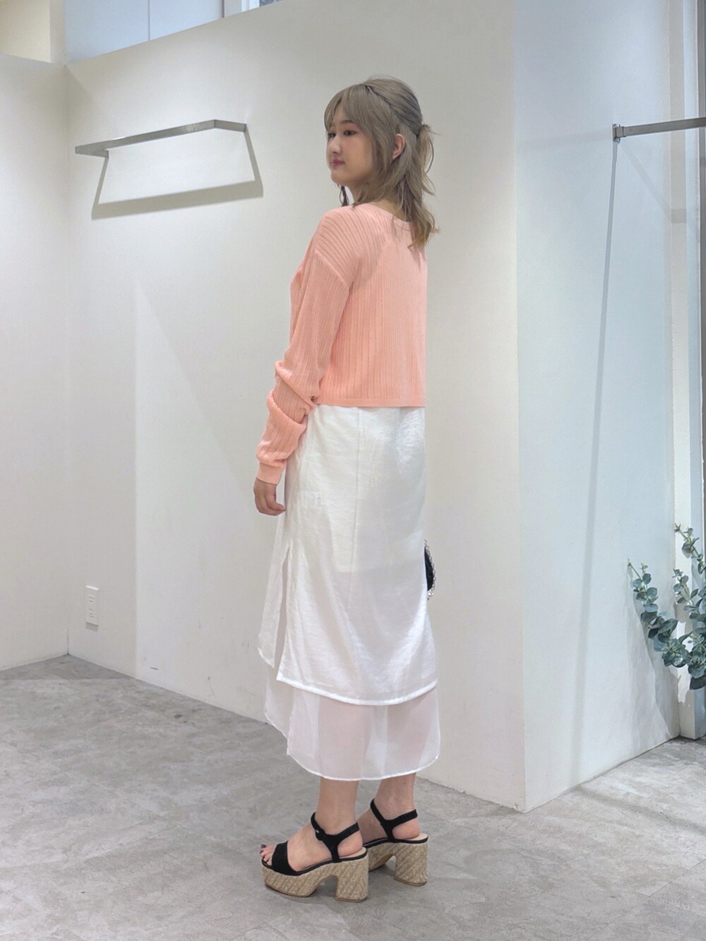 ピンク系のカーディガン/ボレロ、ホワイト系のワンピース、ブラック系のショルダーバッグを着用したレディースの夏コーディネートの3枚目の写真