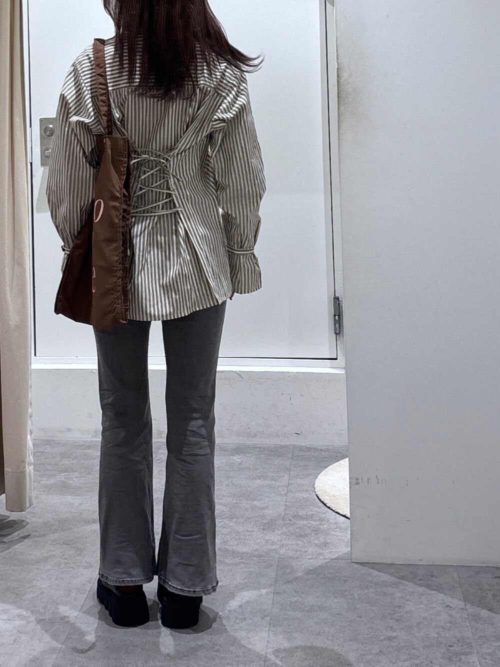 ブラウン系のシャツ/ブラウス、ブラック系のデニムパンツ、ブラウン系のトートバッグを着用したレディースの冬コーディネートの3枚目の写真