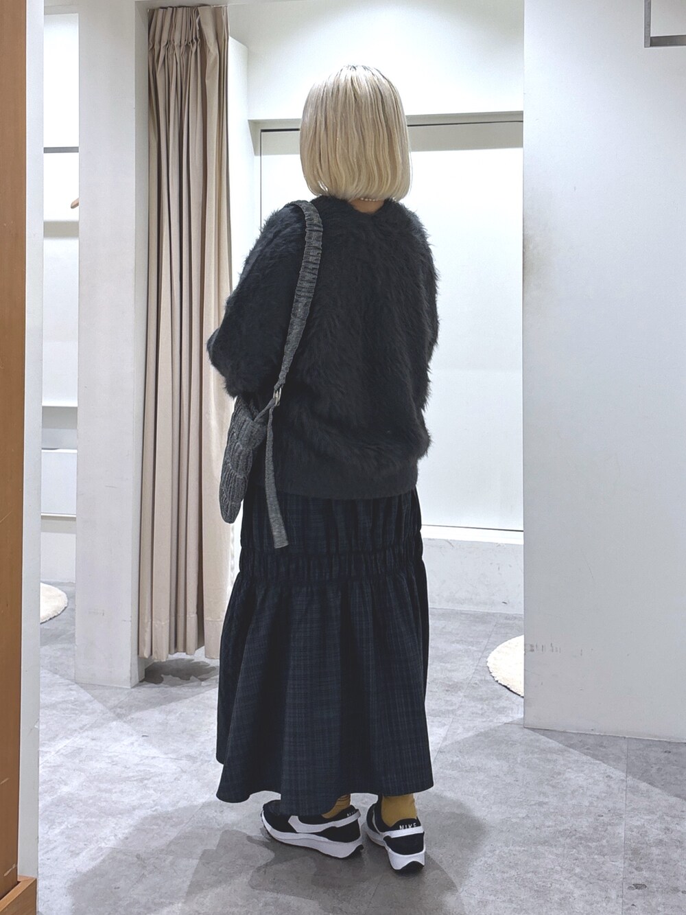 グレー系のスカート、グレー系のカーディガン/ボレロ、ブラック系のキャミソールを着用したレディースの冬コーディネートの4枚目の写真