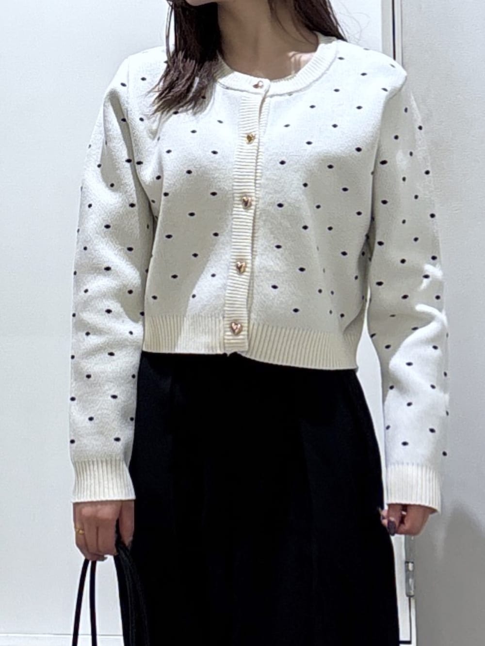 ホワイト系のニット/セーター、ブラック系のスラックスを着用したレディースの冬コーディネートの2枚目の写真