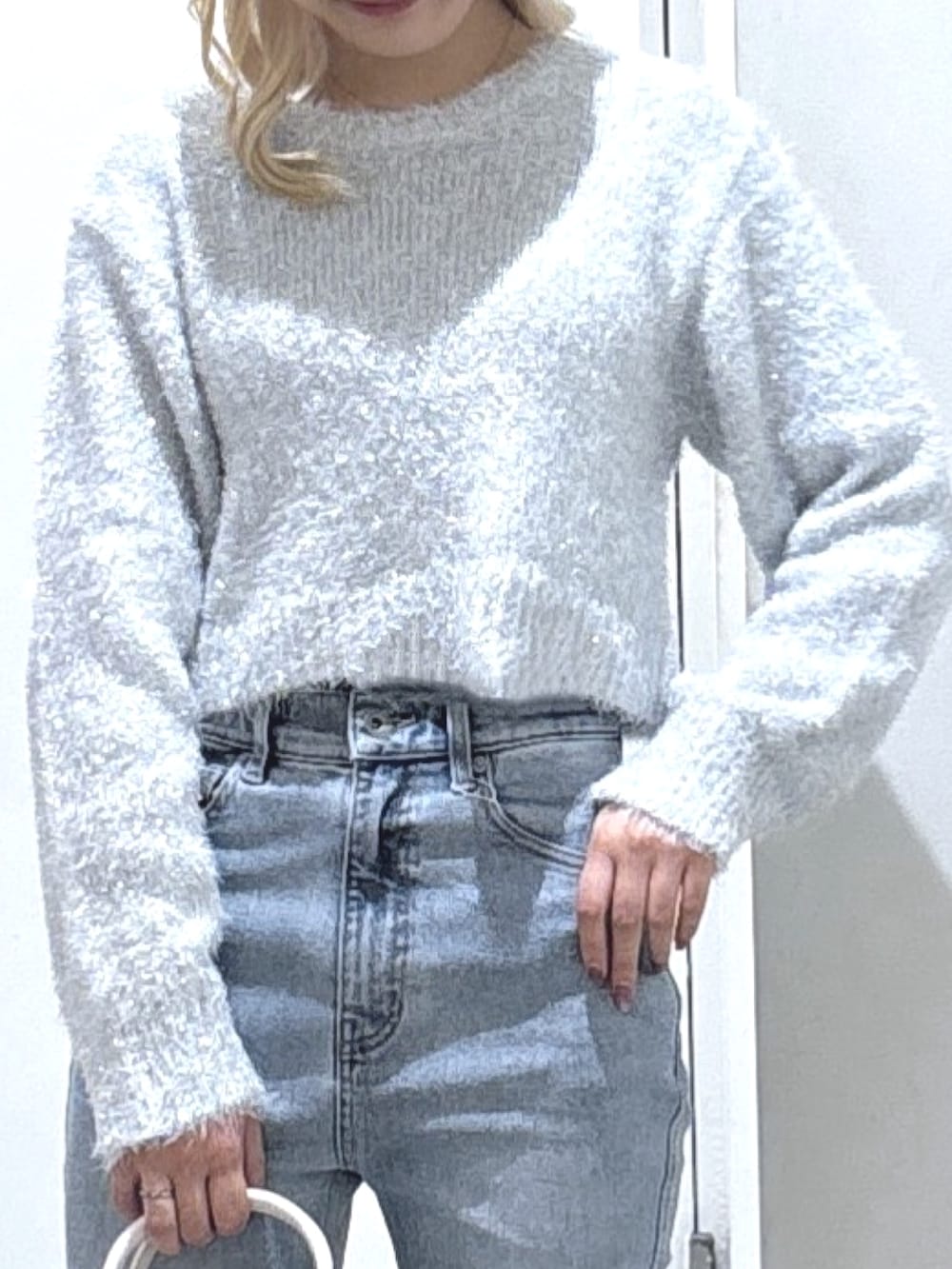 ホワイト系のニット/セーター、ブルー系のデニムパンツを着用したレディースの秋コーディネートの2枚目の写真