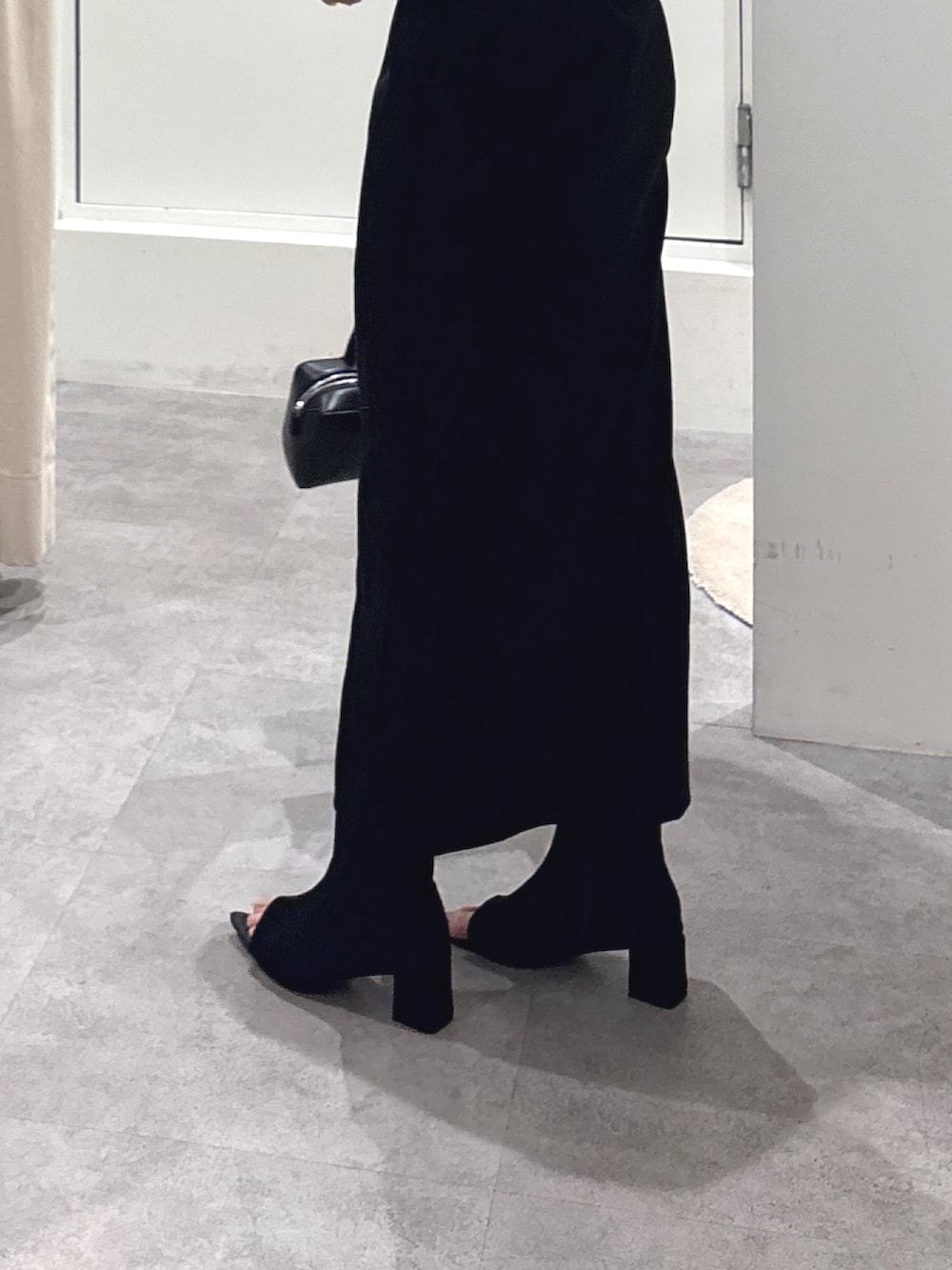 ホワイト系のTシャツ/カットソー、ブラック系のスカート、ブラック系のショルダーバッグを着用したレディースの春コーディネートの4枚目の写真