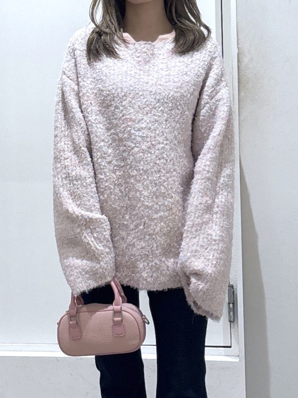 ピンク系のニット/セーター、ブルー系のデニムパンツを着用したレディースの冬コーディネートの2枚目の写真