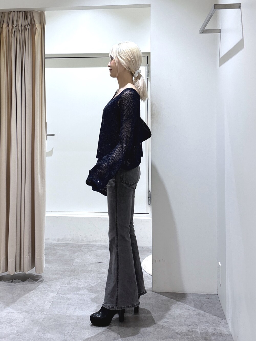 ブルー系のニット/セーター、グレー系のタンクトップ、ブラック系のデニムパンツを着用したレディースの秋コーディネートの3枚目の写真