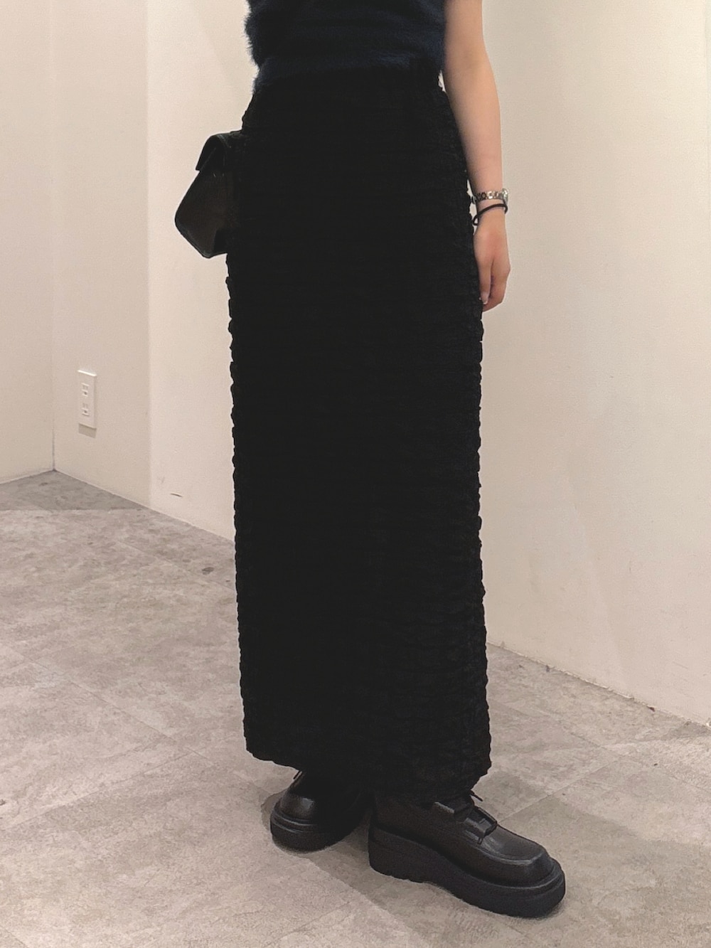 ブルー系のニット/セーター、ブラック系のスカート、ブラック系のブーツを着用したレディースの秋コーディネートの3枚目の写真