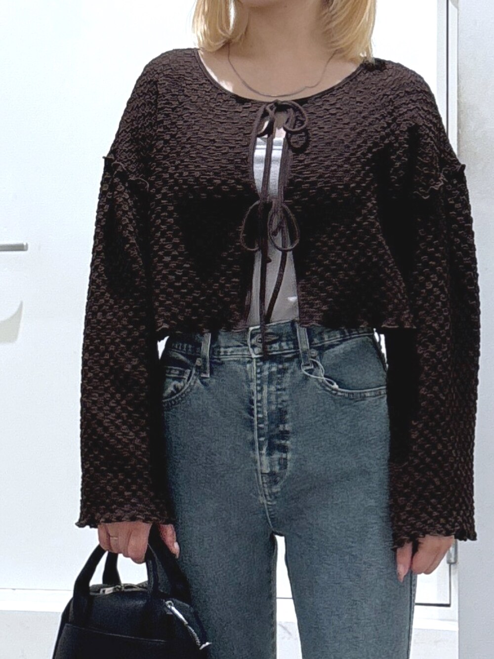 ブラウン系のカーディガン/ボレロ、ブルー系のデニムパンツ、グレー系のキャミソールを着用したレディースの春コーディネートの2枚目の写真
