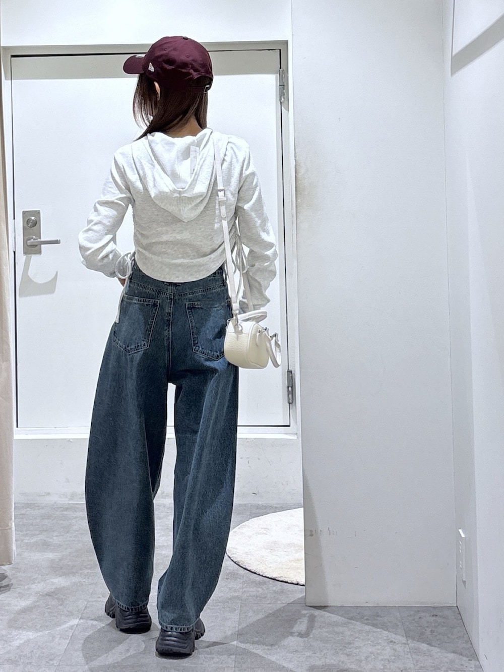 ホワイト系のパーカー、ブルー系のデニムパンツを着用したレディースの冬コーディネートの3枚目の写真