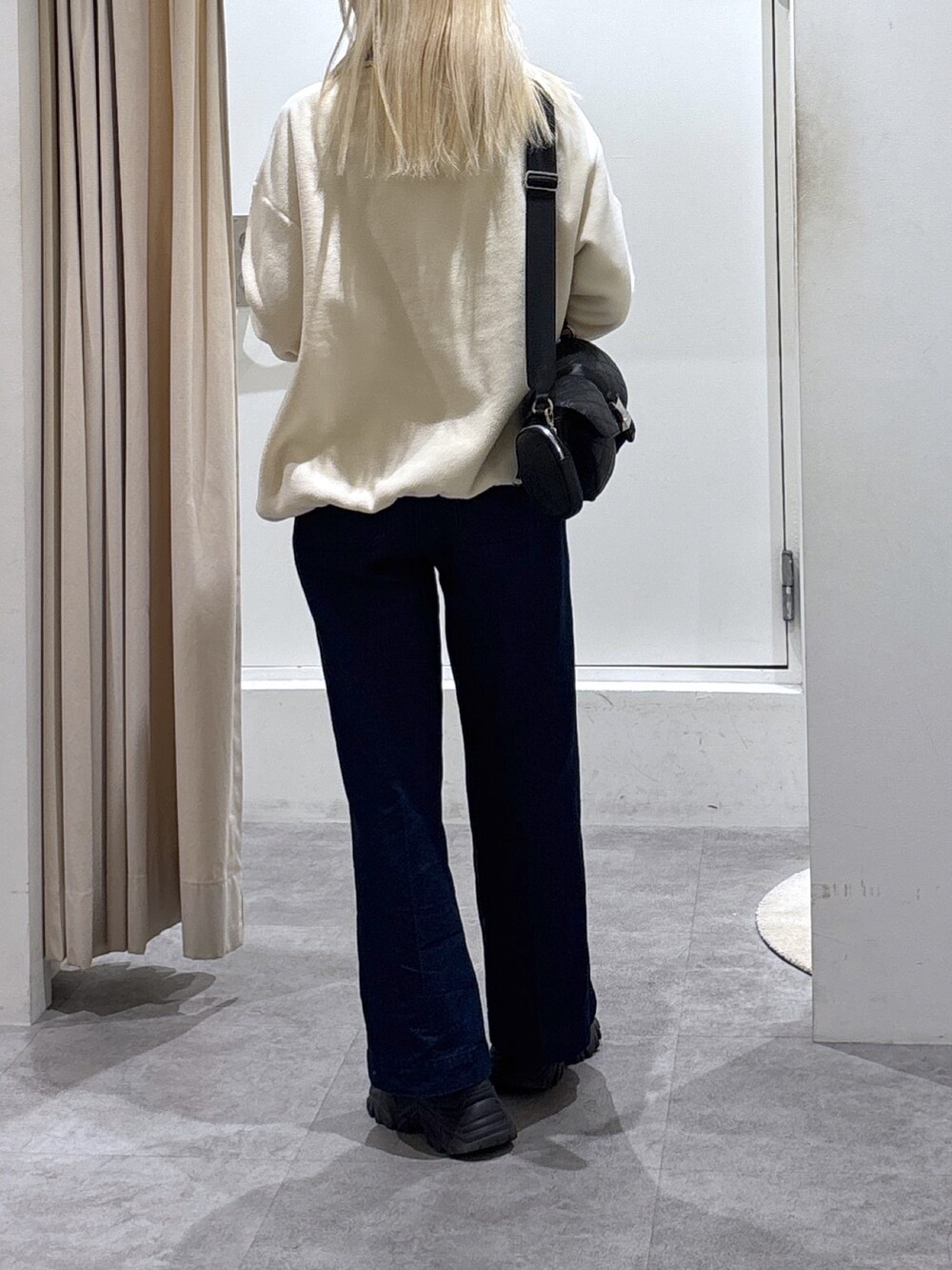 ホワイト系のスウェット、ブルー系のデニムパンツを着用したレディースの秋コーディネートの2枚目の写真