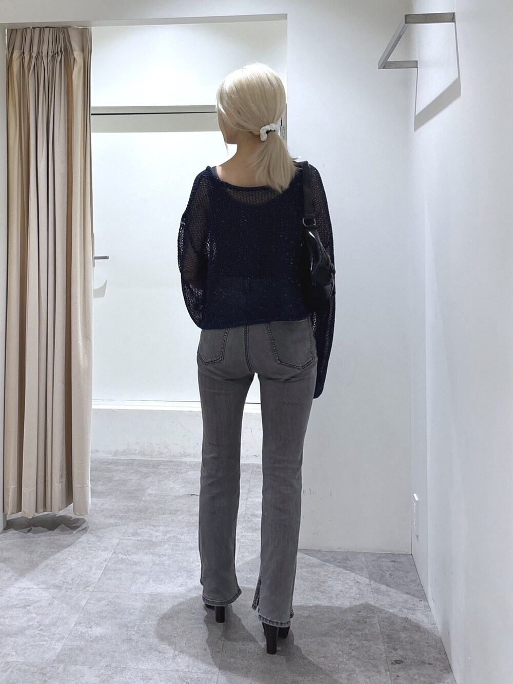 ブルー系のニット/セーター、グレー系のタンクトップ、ブラック系のデニムパンツを着用したレディースの秋コーディネートの4枚目の写真