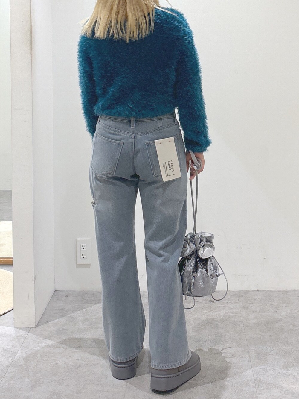 ブルー系のデニムパンツ、グレー系のブーツ、ブルー系のカーディガン/ボレロを着用したレディースの秋コーディネートの4枚目の写真