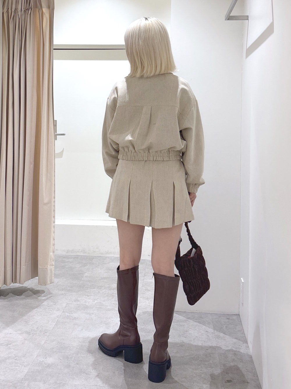 ベージュ系のその他アウター、ベージュ系のスカート、ブラウン系のショルダーバッグを着用したレディースの冬コーディネートの3枚目の写真