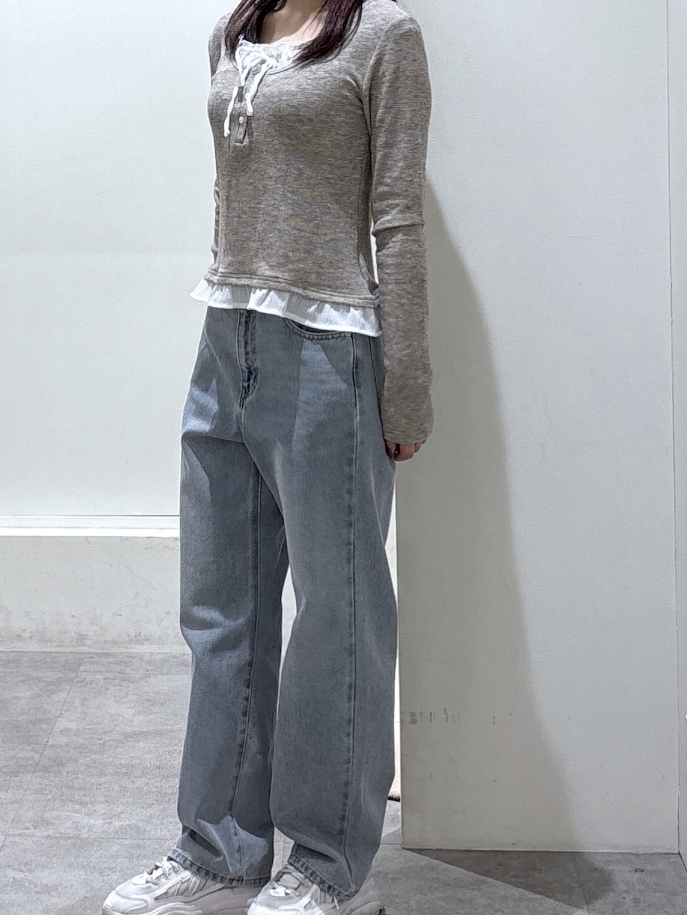 ブラウン系のTシャツ/カットソー、ブルー系のデニムパンツ、ピンク系のボストンバッグを着用したレディースの冬コーディネートの2枚目の写真