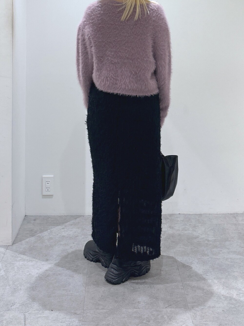 パープル系のカーディガン/ボレロ、ブラック系のワンピース、ブラック系のハンドバッグを着用したレディースの秋コーディネートの4枚目の写真