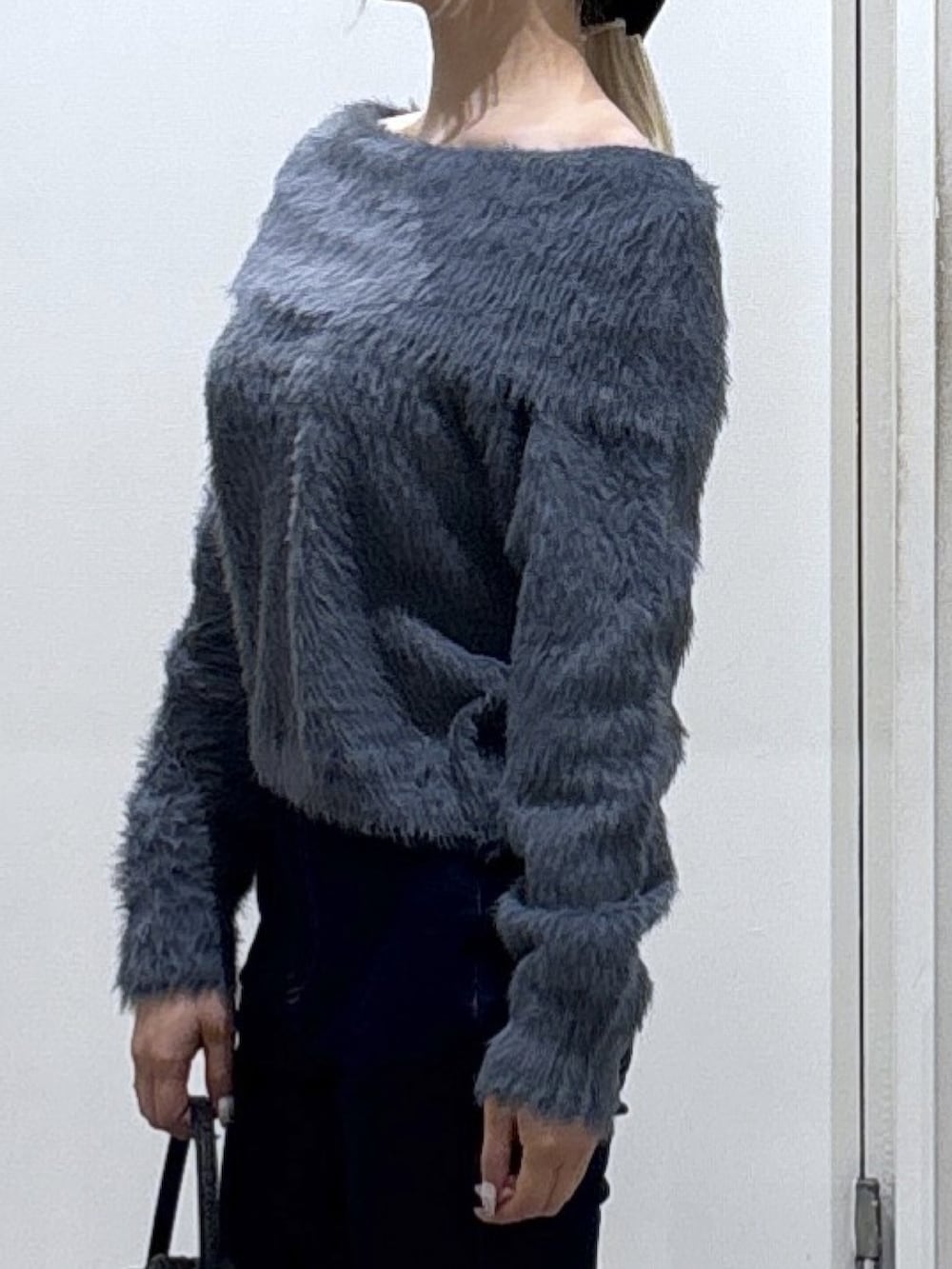 グレー系のニット/セーター、ブルー系のデニムパンツを着用したレディースの冬コーディネートの2枚目の写真