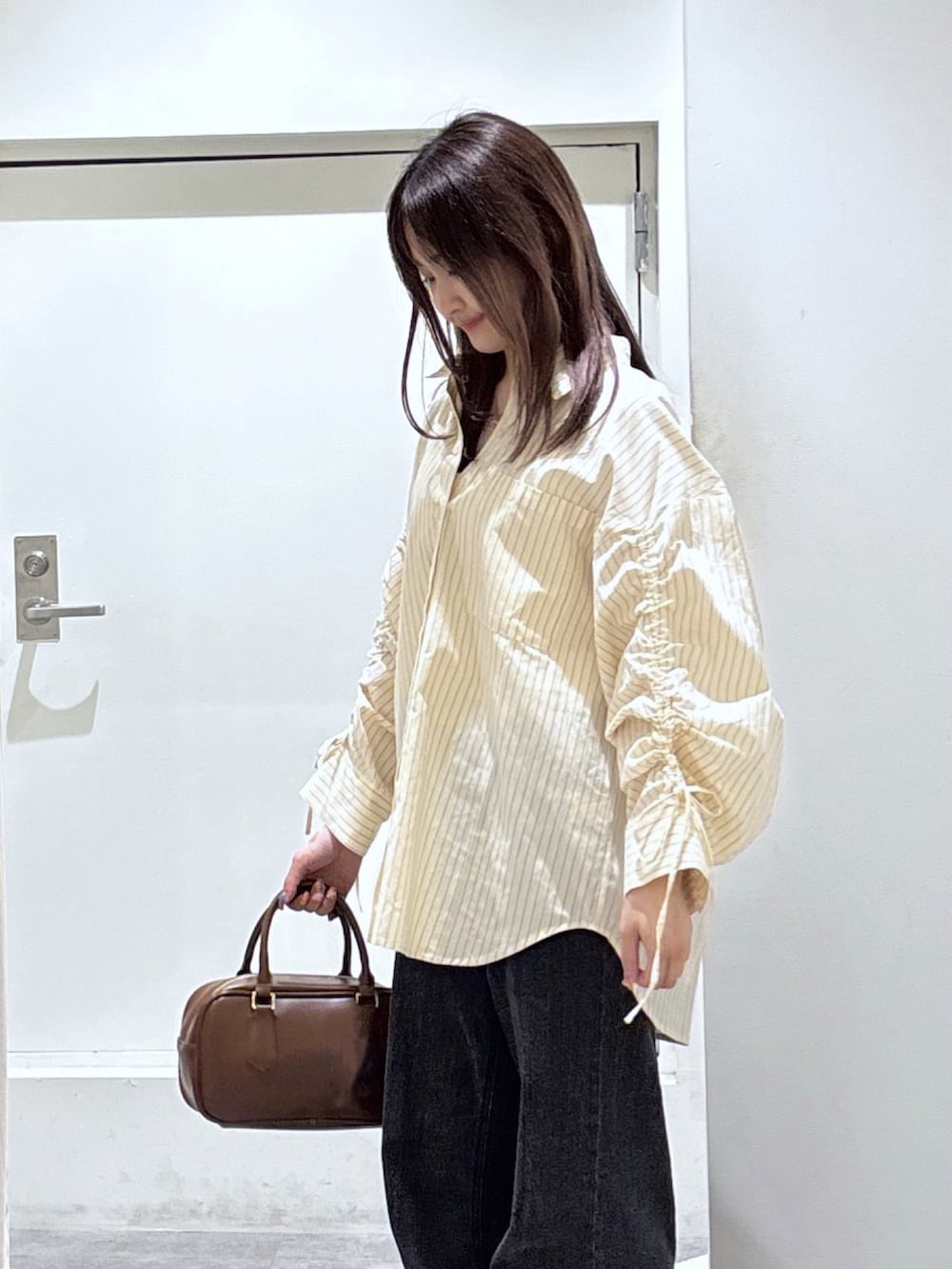 ホワイト系のシャツ/ブラウス、ブラック系のデニムパンツを着用したレディースの冬コーディネートの2枚目の写真