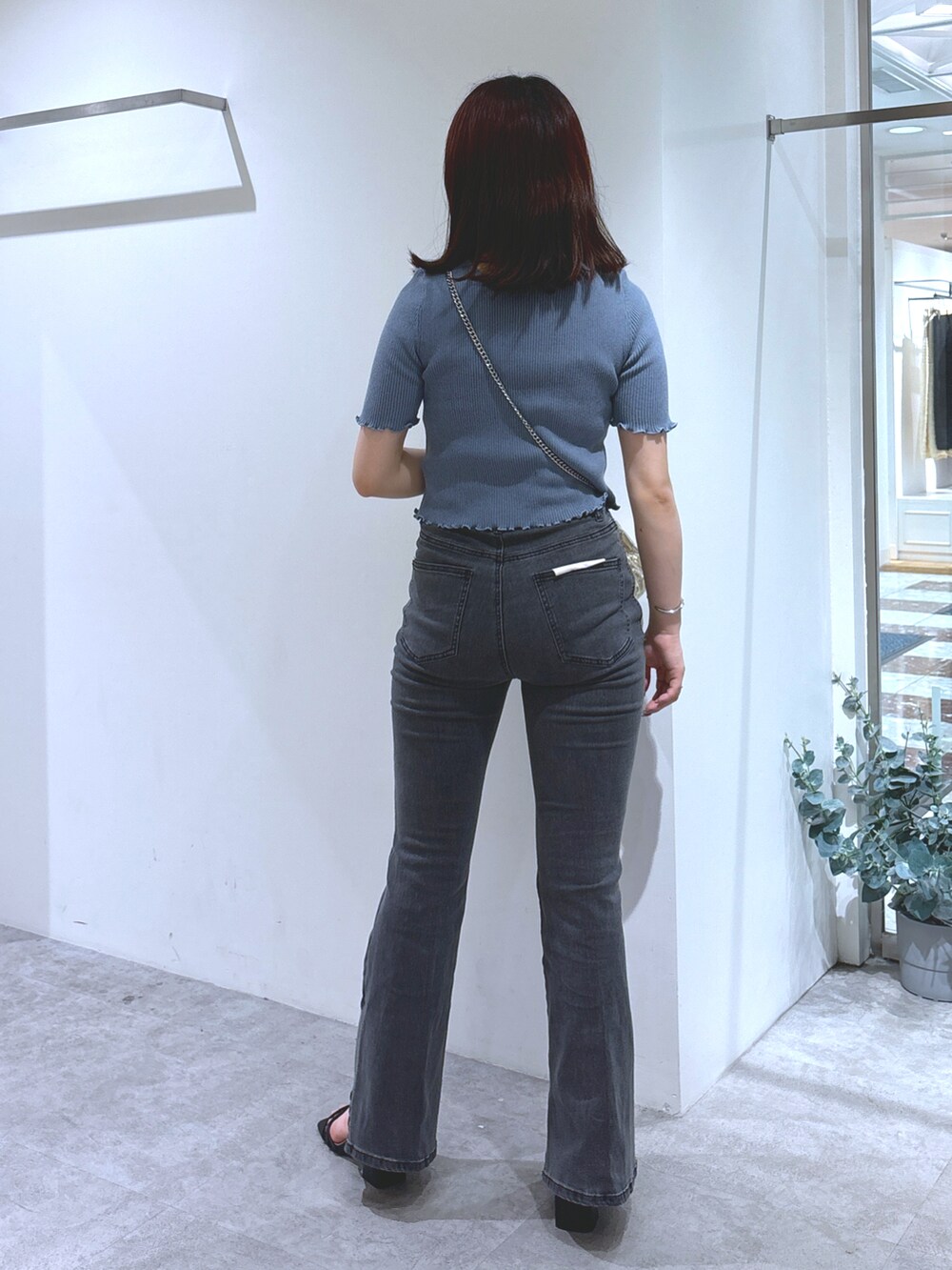 ブルー系のニット/セーター、ブラック系のデニムパンツ、ブラック系のサンダルを着用したレディースの夏コーディネートの3枚目の写真