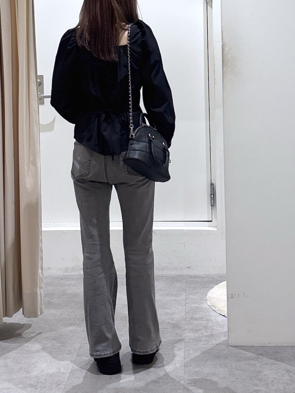 ブラック系のトートバッグ、ブラック系のデニムパンツ、ブラック系のシャツ/ブラウスを着用したレディースの冬コーディネートの4枚目の写真