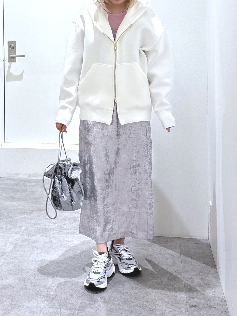 シルバー系のスカート、ピンク系のTシャツ/カットソー、グレー系のハンドバッグを着用したレディースの冬コーディネートの3枚目の写真