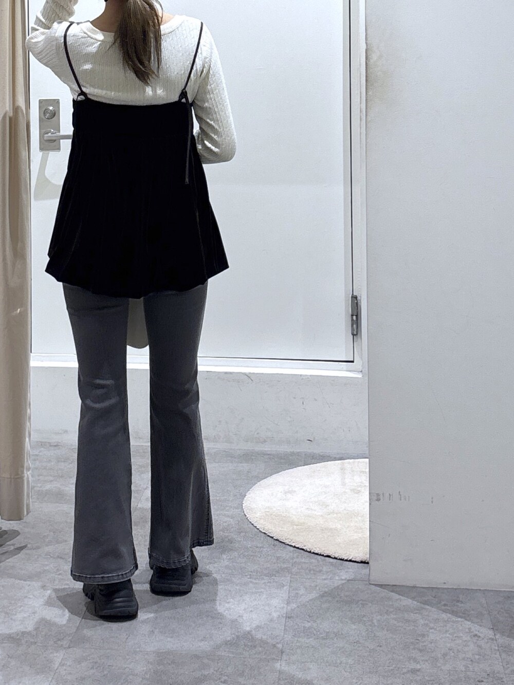 ブラウン系のシャツ/ブラウス、ホワイト系のニット/セーター、ブラック系のデニムパンツを着用したレディースの冬コーディネートの3枚目の写真