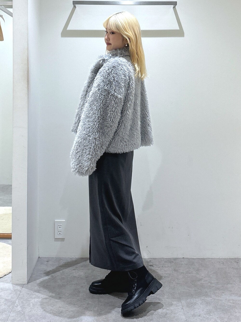 ホワイト系のニット/セーター、グレー系のスカート、シルバー系のトートバッグを着用したレディースの秋コーディネートの4枚目の写真