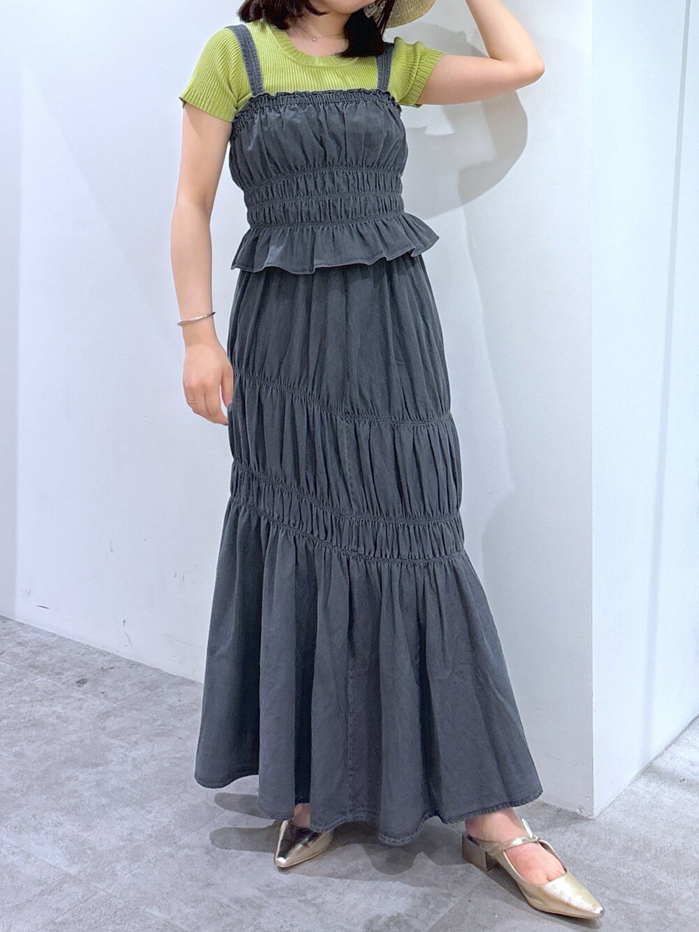 ブラック系のワンピース、グリーン系のニット/セーター、ゴールド系のショルダーバッグを着用したレディースの夏コーディネートの3枚目の写真