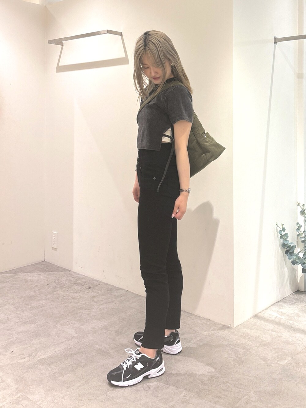 ブラック系のTシャツ/カットソー、ブラック系のデニムパンツ、グリーン系のショルダーバッグを着用したレディースの夏コーディネートの4枚目の写真