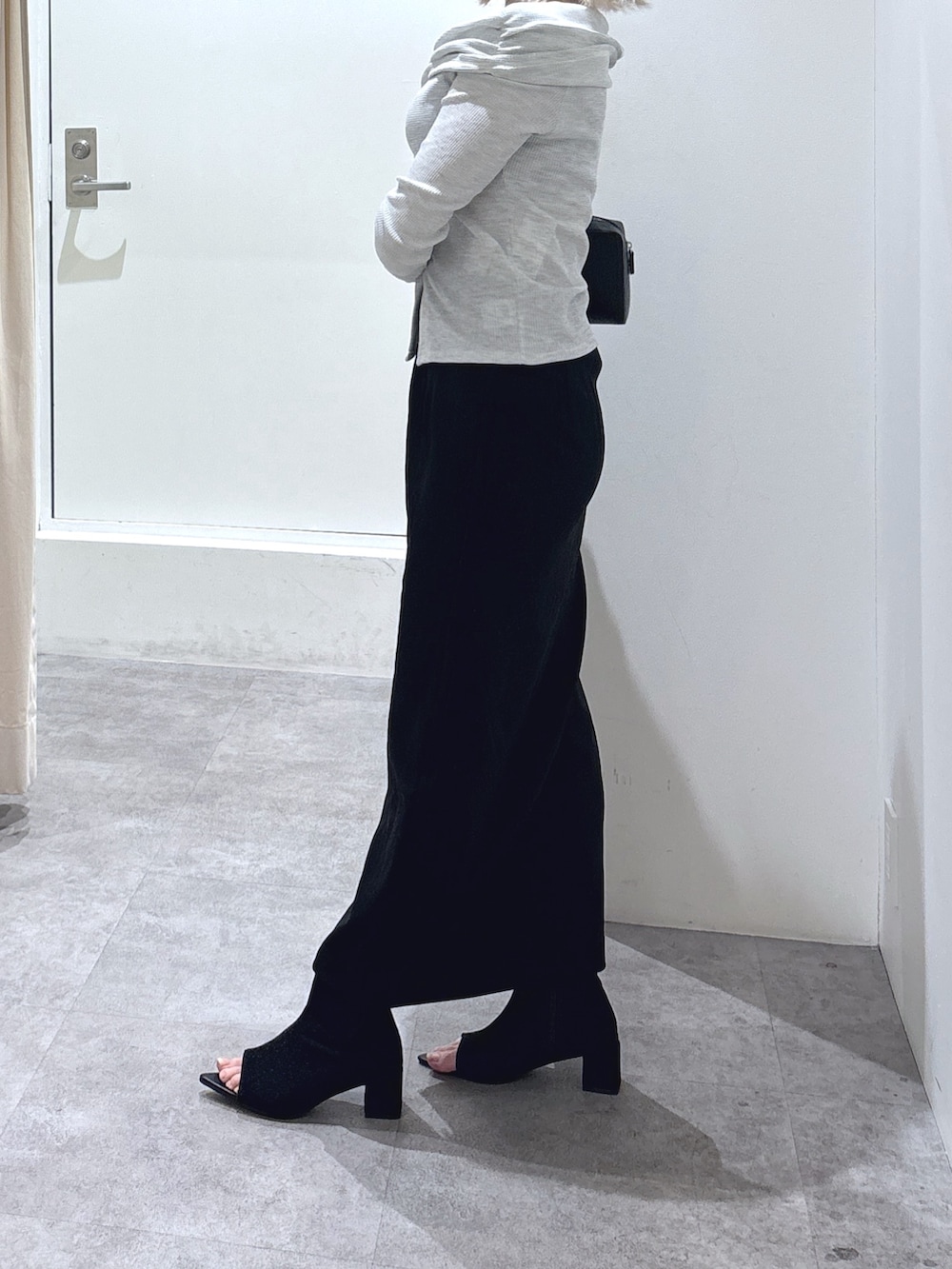 ホワイト系のTシャツ/カットソー、ブラック系のスカート、ブラック系のショルダーバッグを着用したレディースの春コーディネートの3枚目の写真