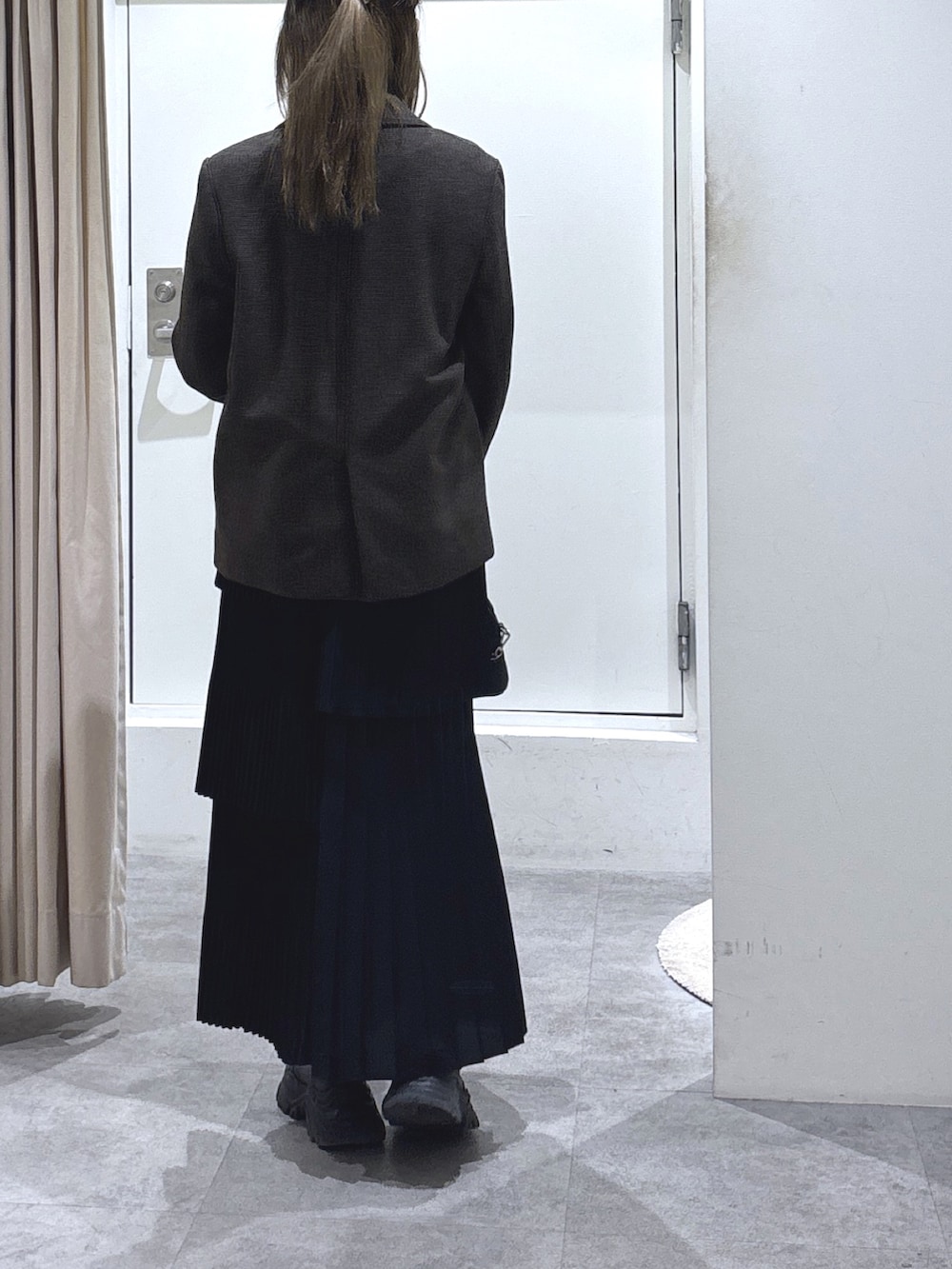 ブラウン系のテーラードジャケット、ブラック系のスカート、ブラック系のトートバッグを着用したレディースの冬コーディネートの3枚目の写真