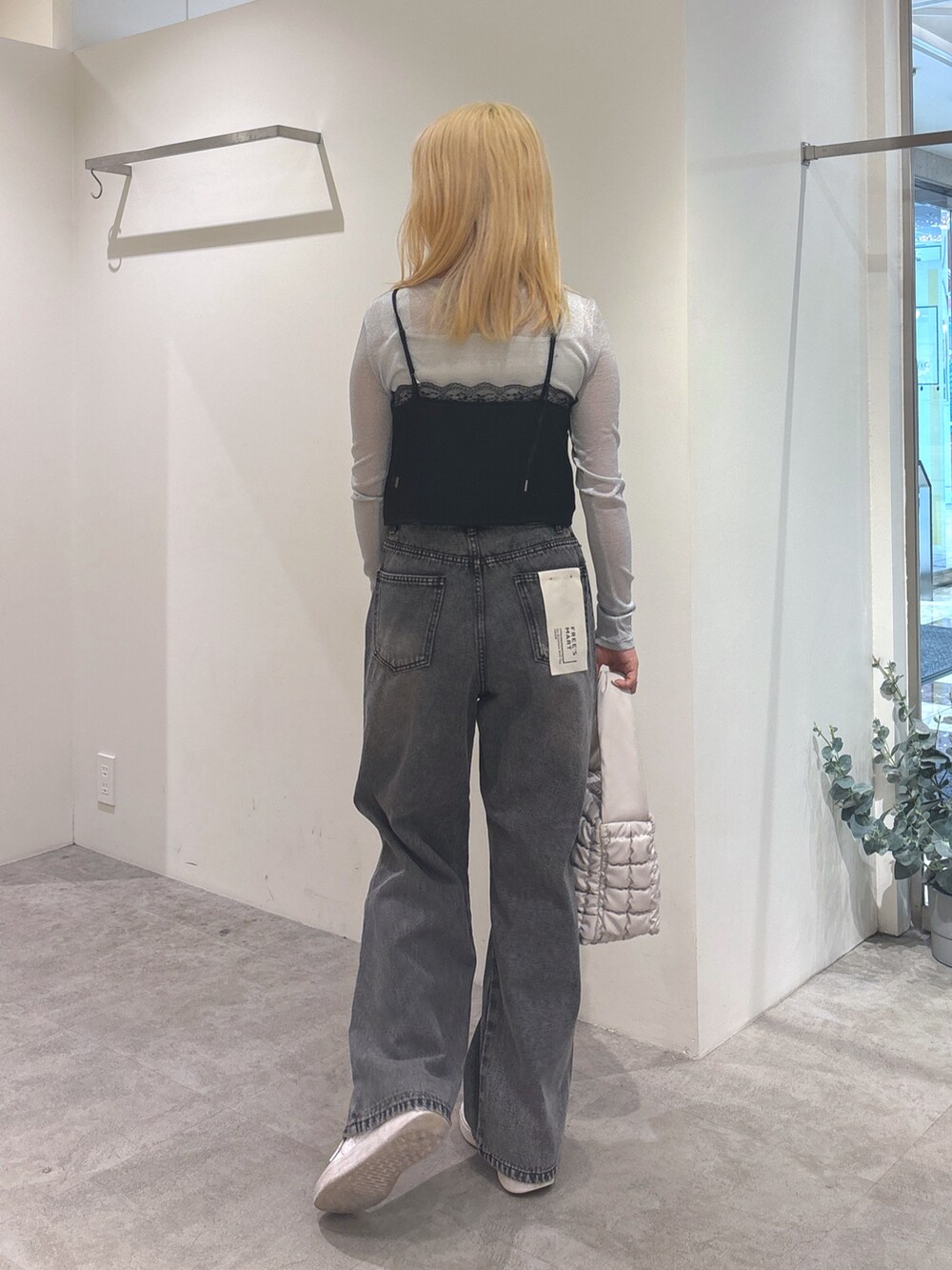 ブラック系のキャミソール、グレー系のTシャツ/カットソー、ブラック系のデニムパンツを着用したレディースの秋コーディネートの4枚目の写真