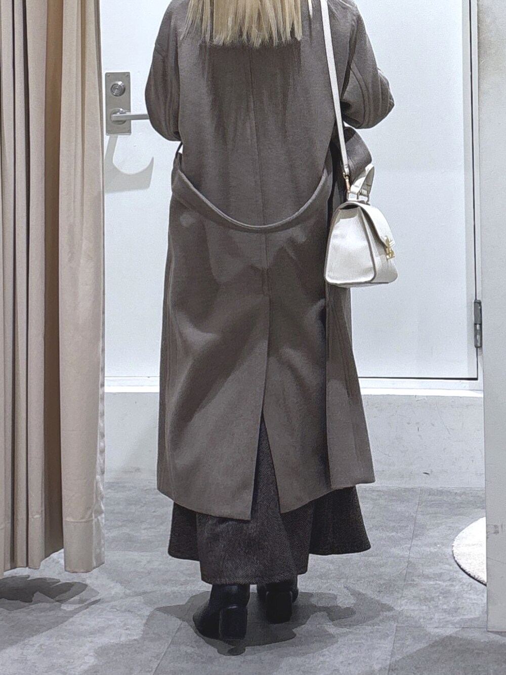 ホワイト系のニット/セーター、ブラウン系のスカート、ブラウン系のステンカラーコートを着用したレディースの秋コーディネートの4枚目の写真