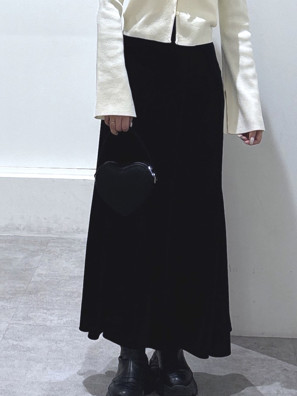 ホワイト系のニット/セーター、ブラック系のスカート、ブラック系のショルダーバッグを着用したレディースの冬コーディネートの5枚目の写真