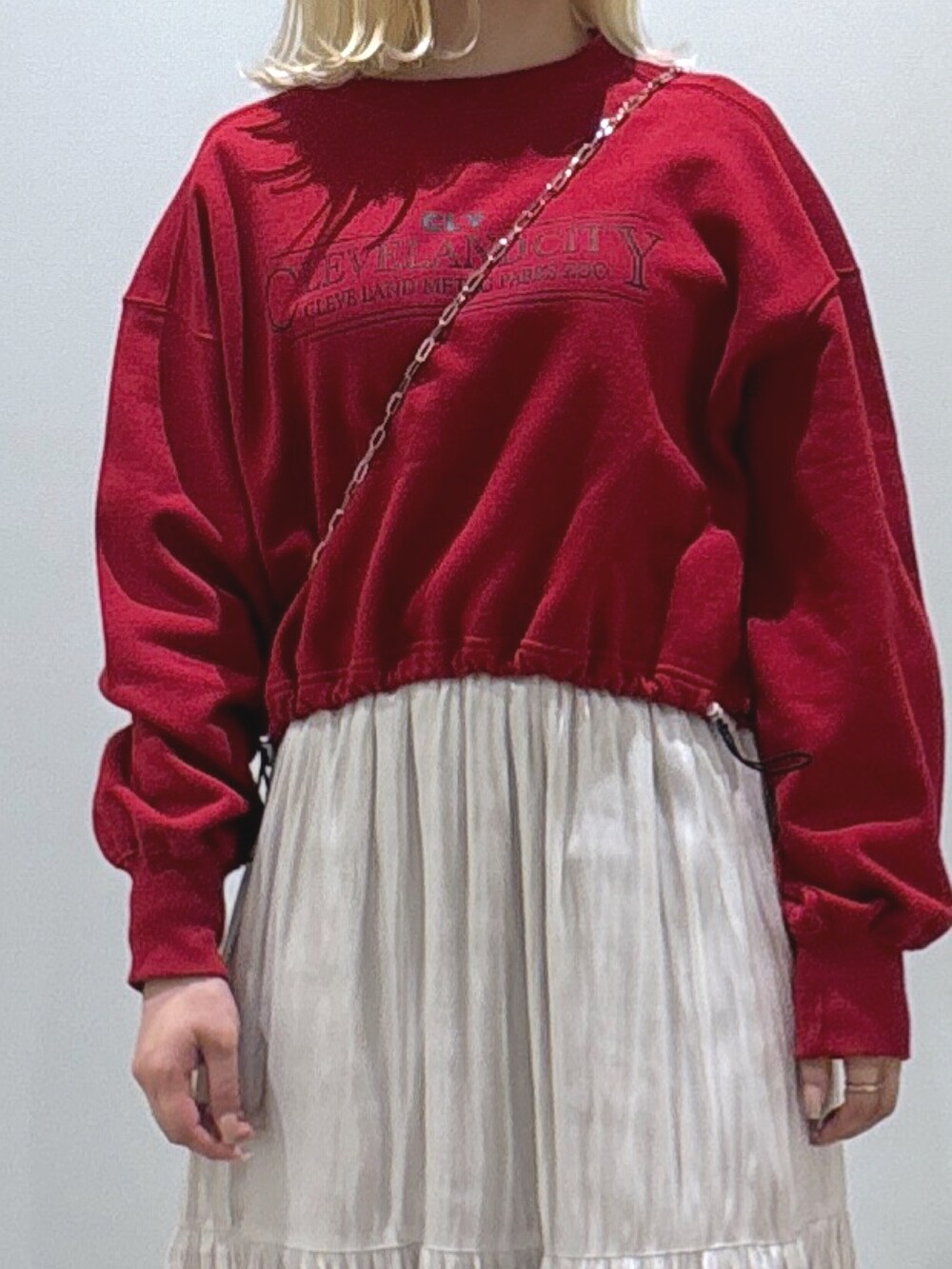 レッド系のTシャツ/カットソー、ホワイト系のスカート、ホワイト系のブーツを着用したレディースの秋コーディネートの2枚目の写真