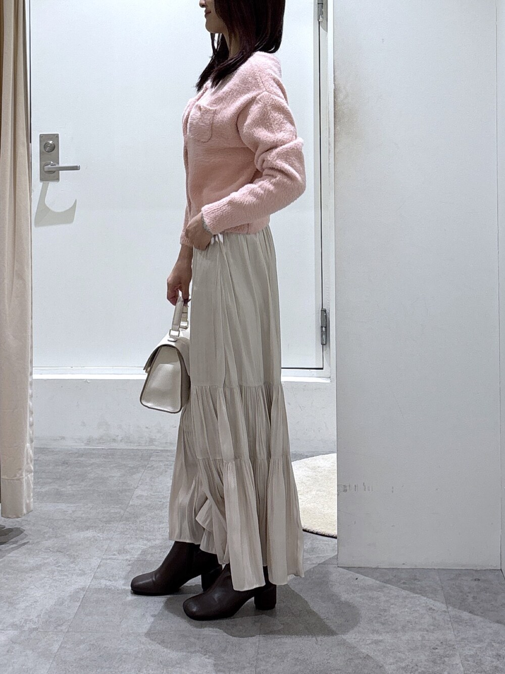 ホワイト系のスカート、ホワイト系のトートバッグ、ピンク系のニット/セーターを着用したレディースの冬コーディネートの3枚目の写真