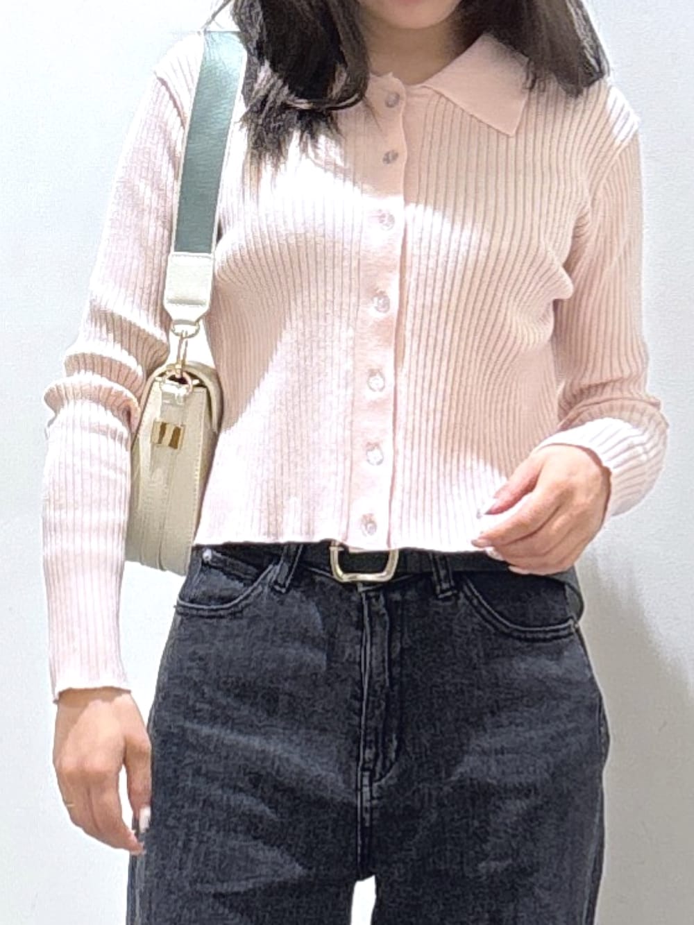 ピンク系のニット/セーター、ブラック系のデニムパンツを着用したレディースの冬コーディネートの2枚目の写真