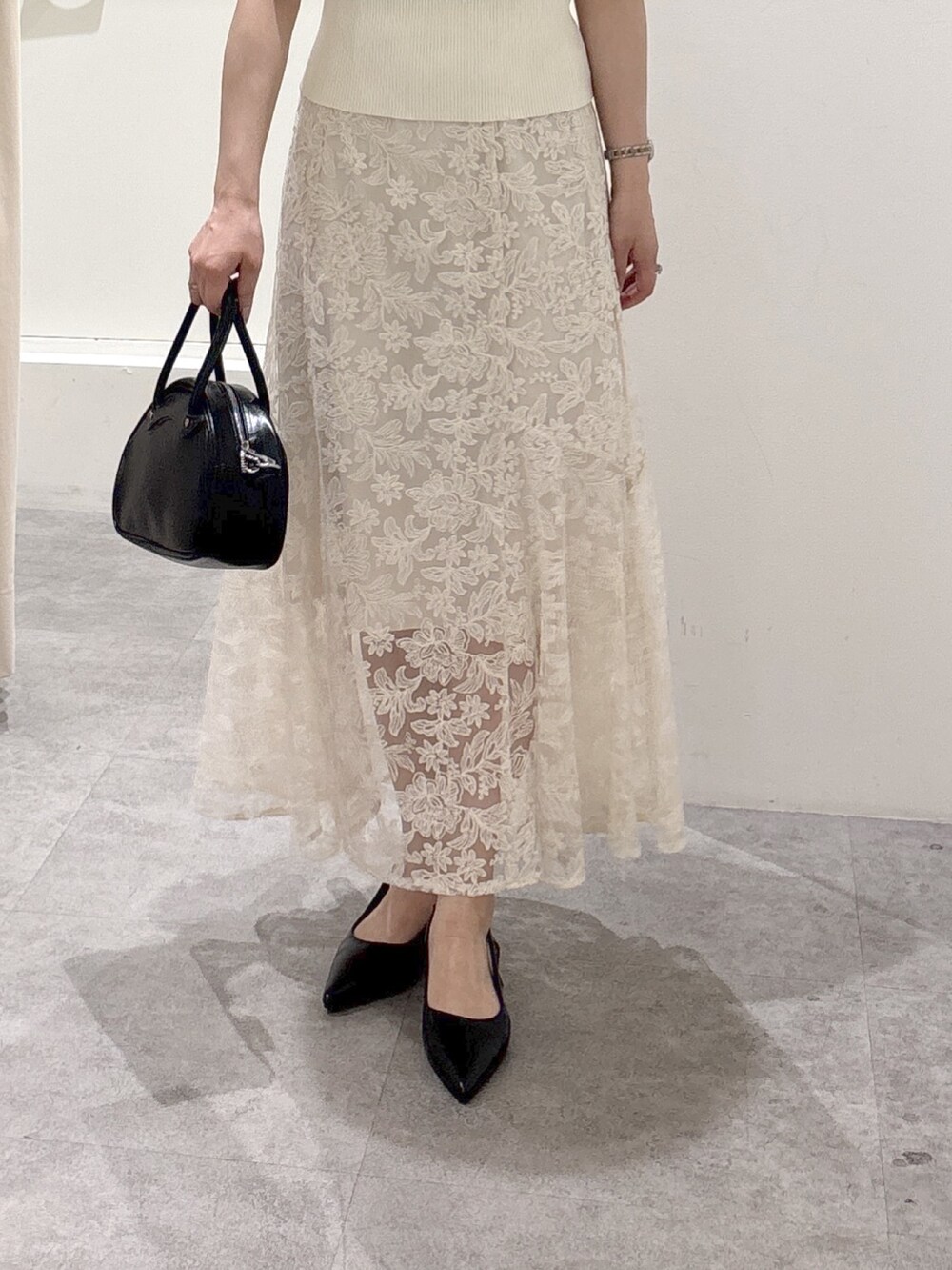 ホワイト系のニット/セーター、ホワイト系のスカートを着用したレディースの夏コーディネートの3枚目の写真