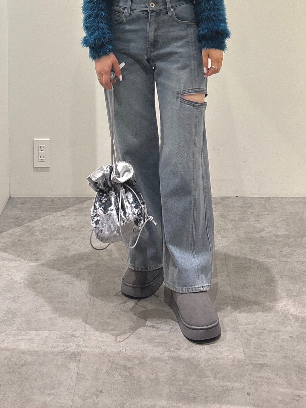 ブルー系のデニムパンツ、グレー系のブーツ、ブルー系のカーディガン/ボレロを着用したレディースの秋コーディネートの3枚目の写真