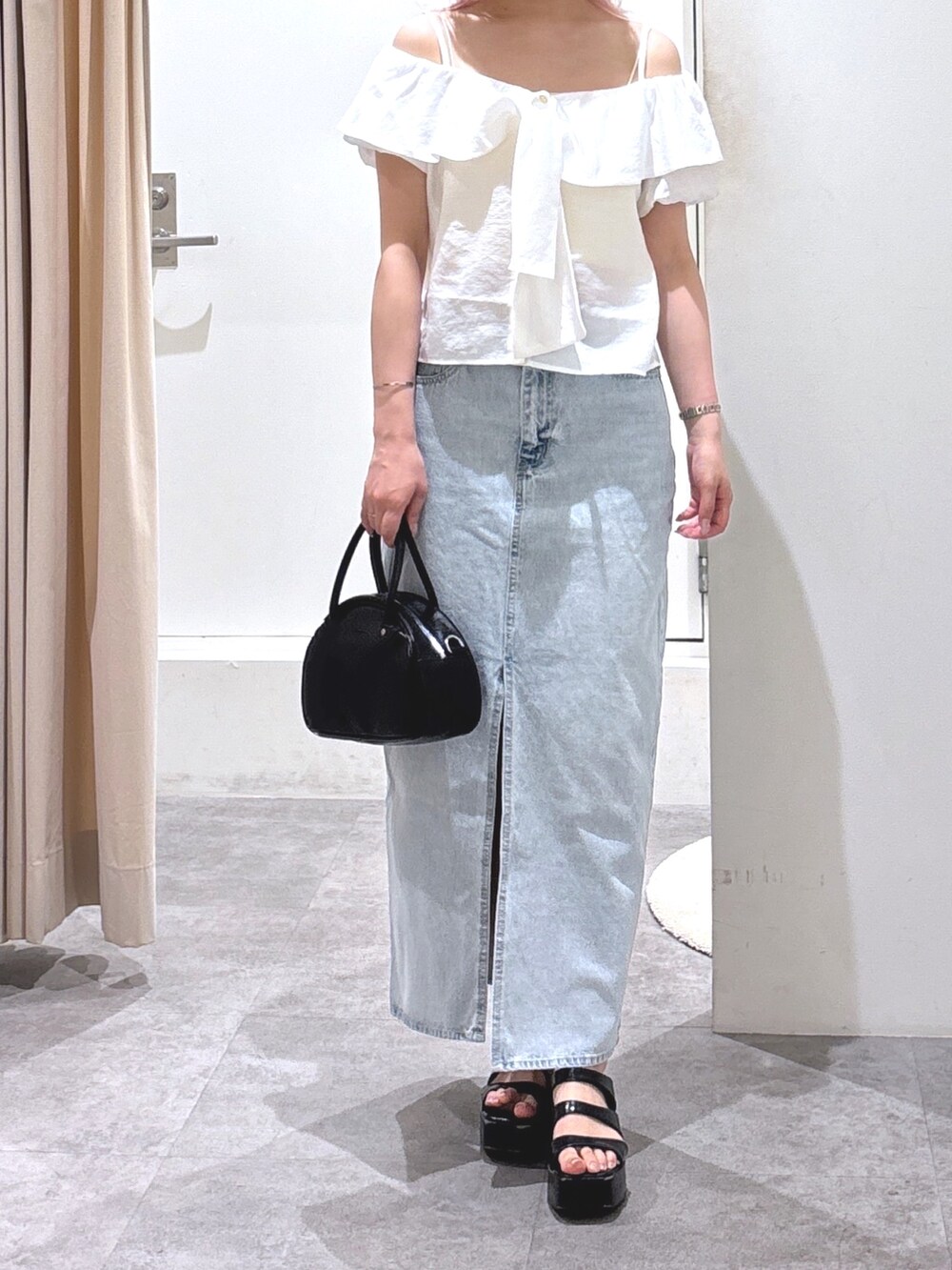 ホワイト系のシャツ/ブラウス、ブルー系のデニムスカートを着用したレディースの夏コーディネートの2枚目の写真