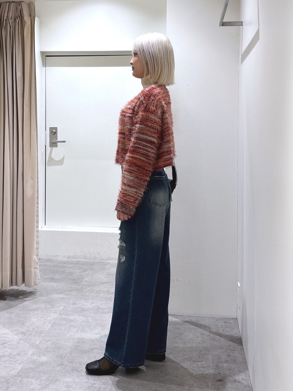 ブルー系のデニムパンツ、レッド系のニット/セーター、ホワイト系のTシャツ/カットソーを着用したレディースの冬コーディネートの3枚目の写真