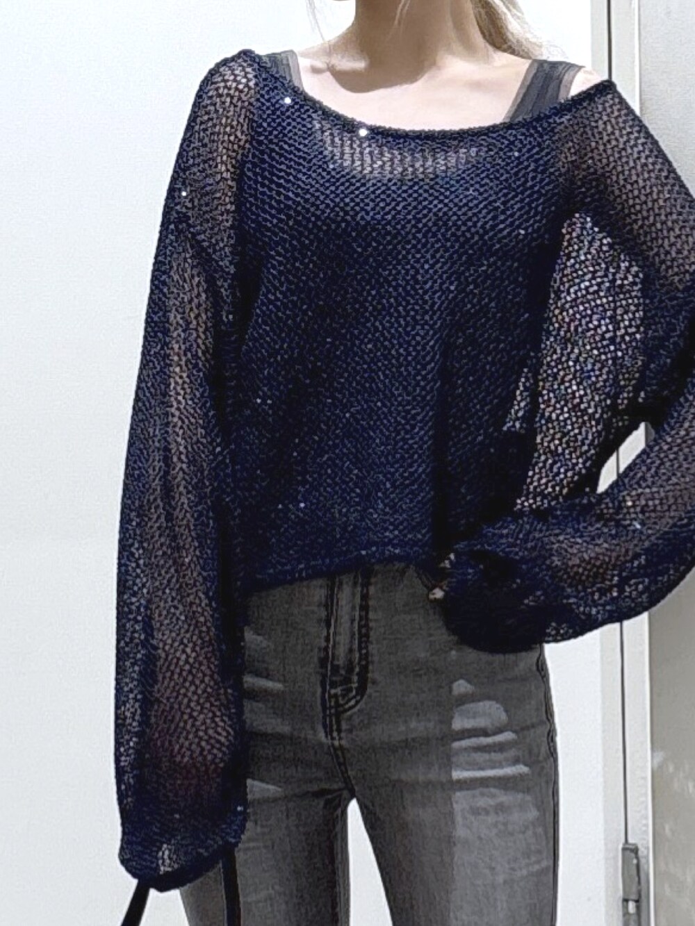 ブルー系のニット/セーター、グレー系のタンクトップ、ブラック系のデニムパンツを着用したレディースの秋コーディネートの2枚目の写真