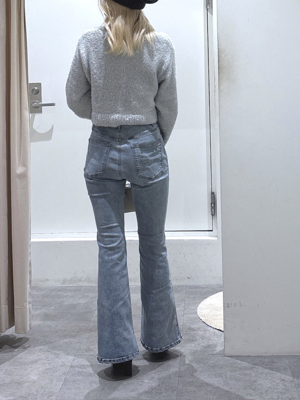 ホワイト系のニット/セーター、ブルー系のデニムパンツを着用したレディースの秋コーディネートの3枚目の写真