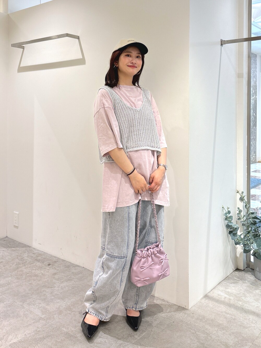 シルバー系のベスト、ピンク系のTシャツ/カットソー、ブルー系のデニムパンツを着用したレディースの夏コーディネートの3枚目の写真