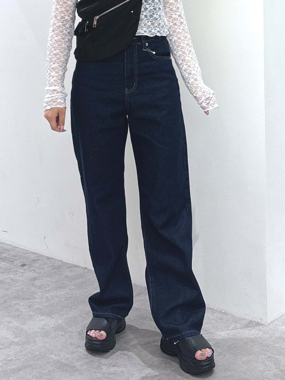 ホワイト系のTシャツ/カットソー、ブラック系のショルダーバッグ、ブルー系のデニムパンツを着用したレディースの秋コーディネートの3枚目の写真