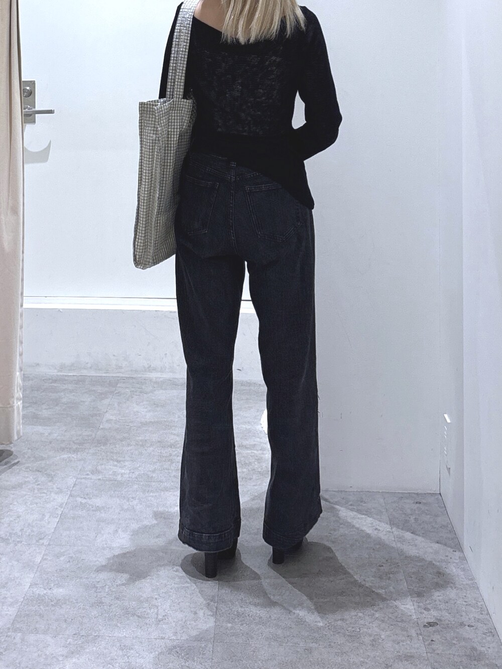 ブラック系のTシャツ/カットソー、ブラック系のデニムパンツ、ブラック系のブーツを着用したレディースの秋コーディネートの3枚目の写真