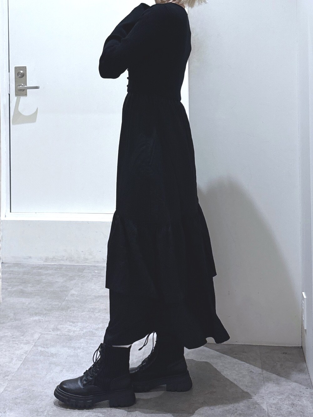 ブラック系のワンピース、ブラック系のブーツ、ブラック系のショルダーバッグを着用したレディースの冬コーディネートの4枚目の写真