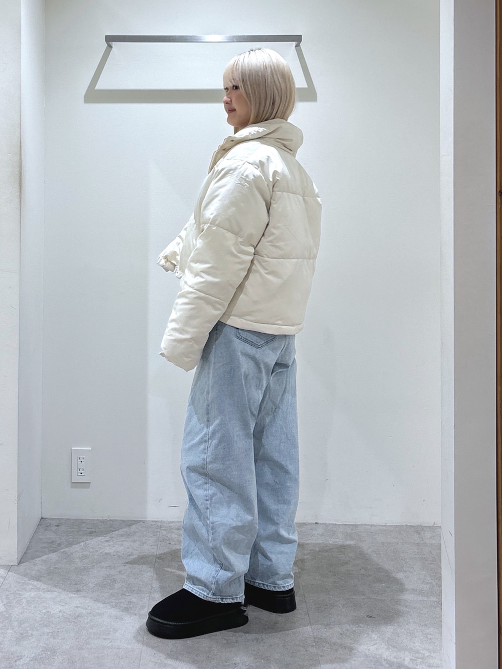 ホワイト系のブルゾン、ブルー系のデニムパンツ、ホワイト系のスウェットを着用したレディースの秋コーディネートの2枚目の写真