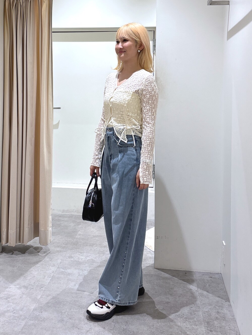 ホワイト系のカーディガン/ボレロ、ブルー系のデニムパンツ、ホワイト系のスニーカーを着用したレディースの春コーディネートの3枚目の写真