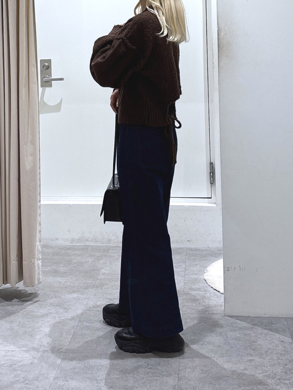 ブラウン系のニット/セーターを着用したレディースの冬コーディネートの4枚目の写真