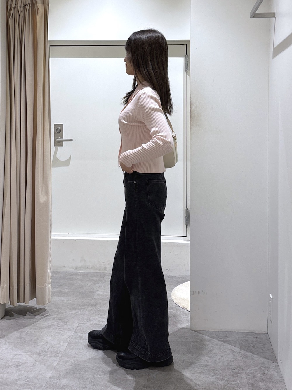 ピンク系のニット/セーター、ブラック系のデニムパンツを着用したレディースの冬コーディネートの4枚目の写真